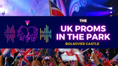 A backdrop of a crowd with neon text reading 'UK Proms in the Park'